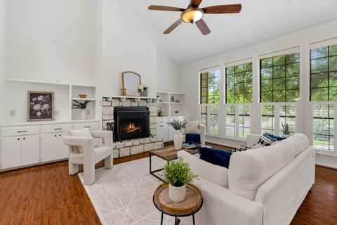 a living room with furniture a fireplace and a floor to ceiling window