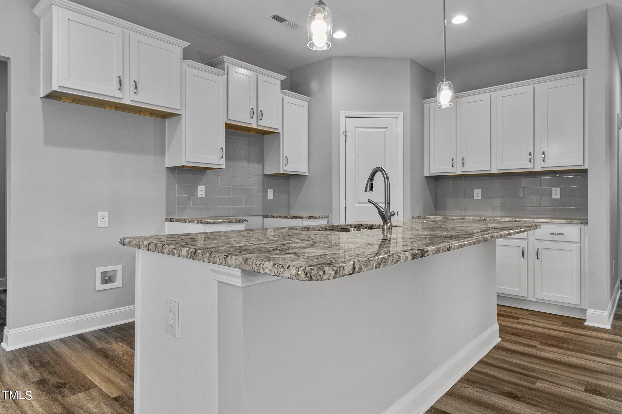 75 Regis Lane Coats, NC 27521 - Photo 15 of 37 a kitchen with granite countertop a sink white cabinets and a granite counter tops