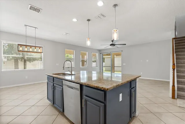 a kitchen with granite countertop cabinets a sink a window and stainless steel appliances