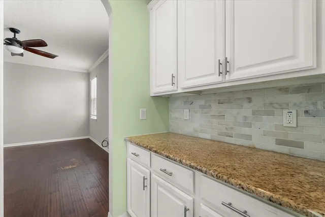 a kitchen with granite countertop white cabinets and a sink