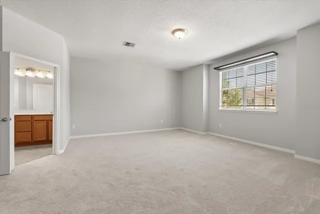 an empty room with a window and a bathroom