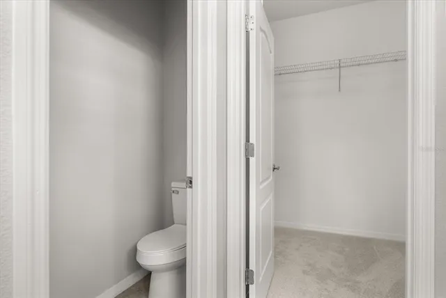 a bathroom with a granite countertop toilet and a sink