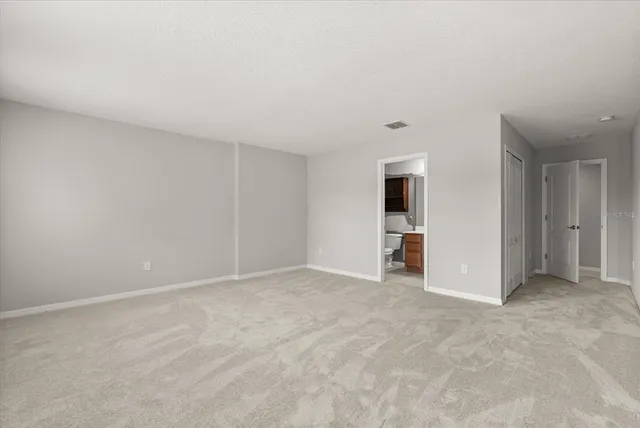 a view of an empty room with closet and entryway