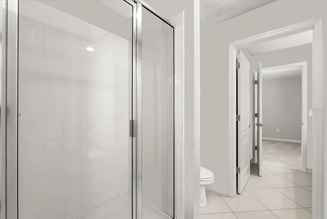a bathroom with a granite countertop toilet and a shower