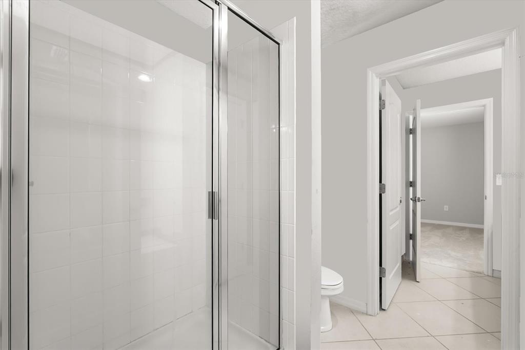 4345 Saltmarsh Sparrow Drive Windermere, FL 34786 - Photo 36 of 46 a bathroom with a granite countertop toilet and a shower