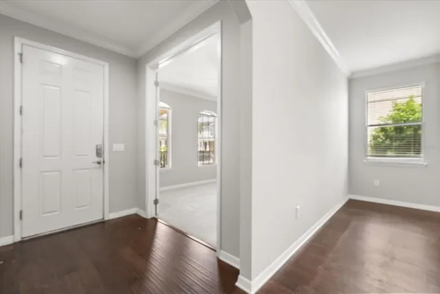 an empty room with wooden floor mirror and windows