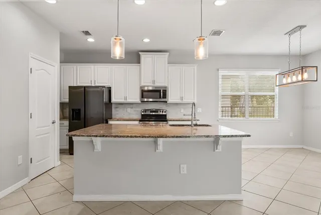 a kitchen with kitchen island a refrigerator a stove a sink and a microwave