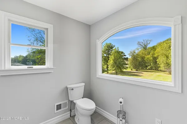 a bathroom with a toilet and a window