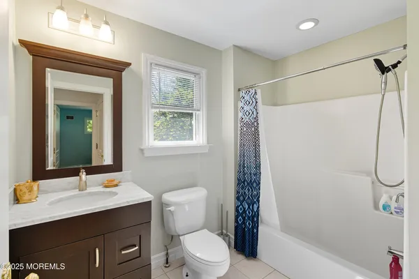 a bathroom with a sink toilet a mirror and shower