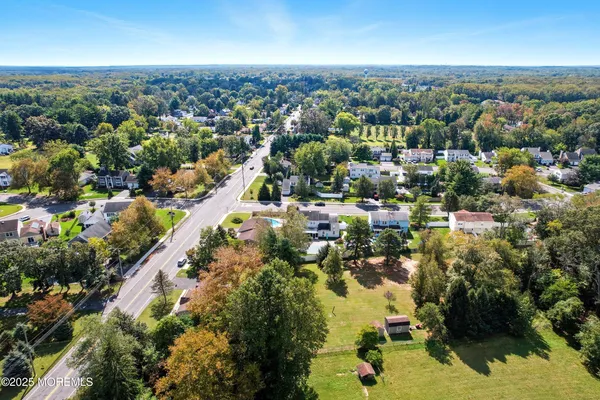 an aerial view of residential houses with outdoor space and trees