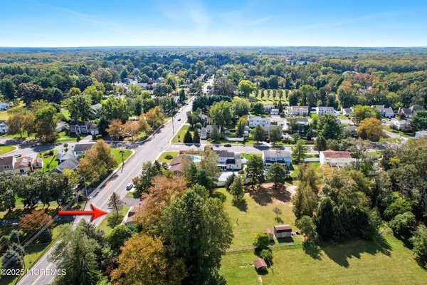 an aerial view of residential houses with outdoor space and trees