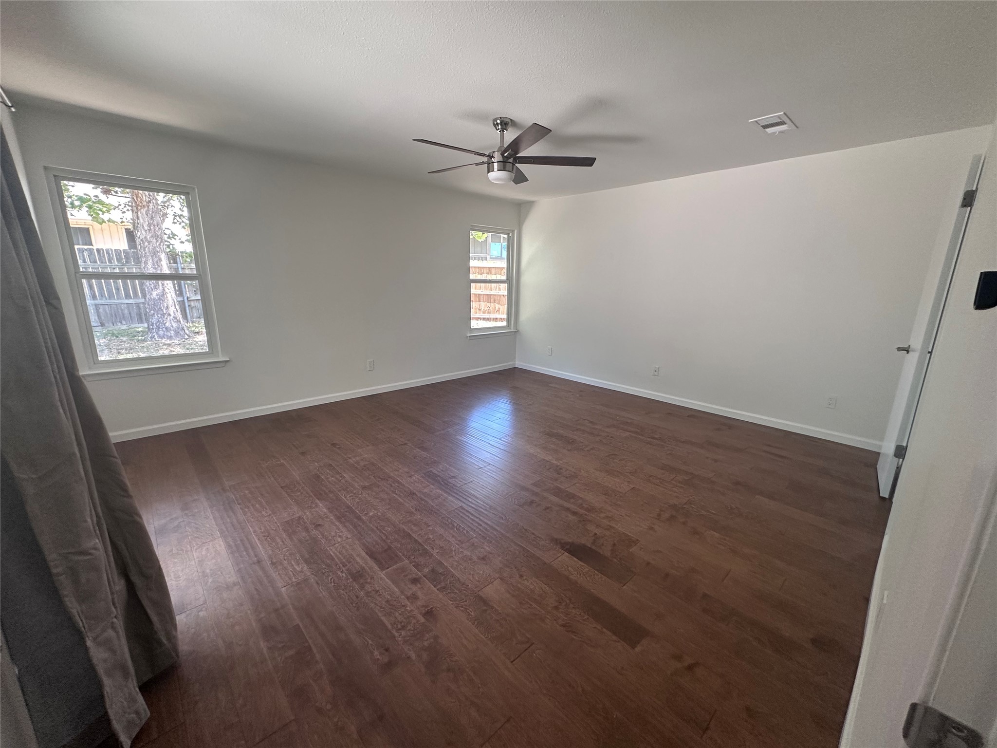 12610 Andromeda Cove Austin, TX 78727 - Photo 16 of 29 Rich wood floors lay a warm foundation for this airy bedroom with dual aspect windows.