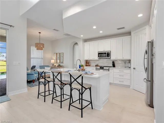 a kitchen with cabinets and chairs