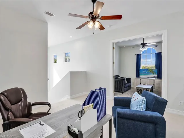a living room with furniture and a ceiling fan