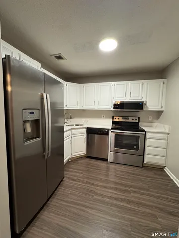 a kitchen with wooden cabinets stainless steel appliances and a window