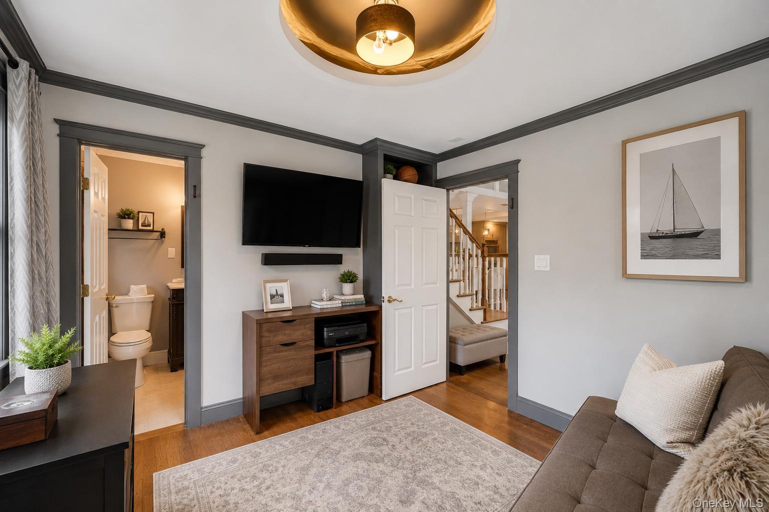 19 Joan Road Bay Shore, NY 11706 - Photo 18 of 50 Interior space featuring dark wood-finish flooring, light grey walls with contrasting dark trim, and multiple windows providing natural illumination