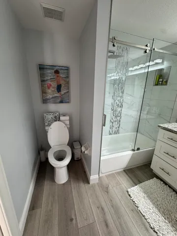 a bathroom with a toilet and a shower