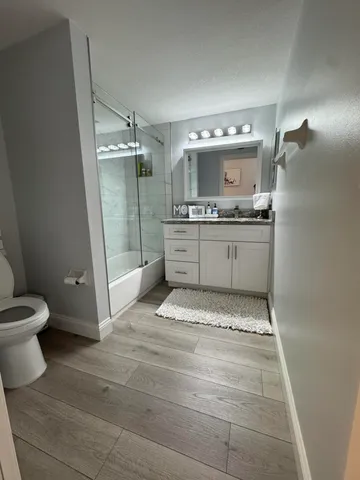 a bathroom with a granite countertop sink toilet and shower