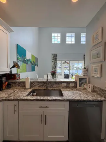 a kitchen with granite countertop stainless steel appliances sink and window