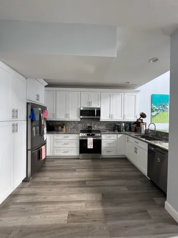 a large kitchen with cabinets and stainless steel appliances