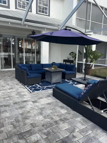 a living room with a couch a dining table and chairs with wooden floor