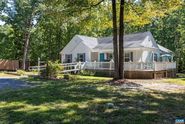 a view of a house with a big yard and large trees