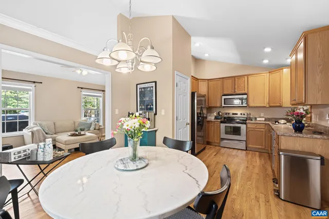 a kitchen with stainless steel appliances kitchen island granite countertop a stove a kitchen island a dining table and chairs