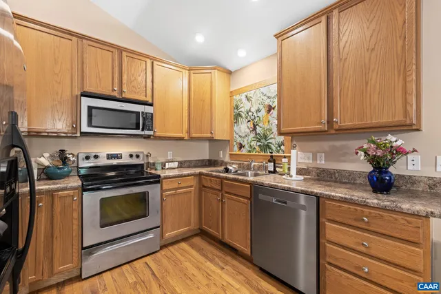 a kitchen with stainless steel appliances granite countertop a stove a sink and a microwave
