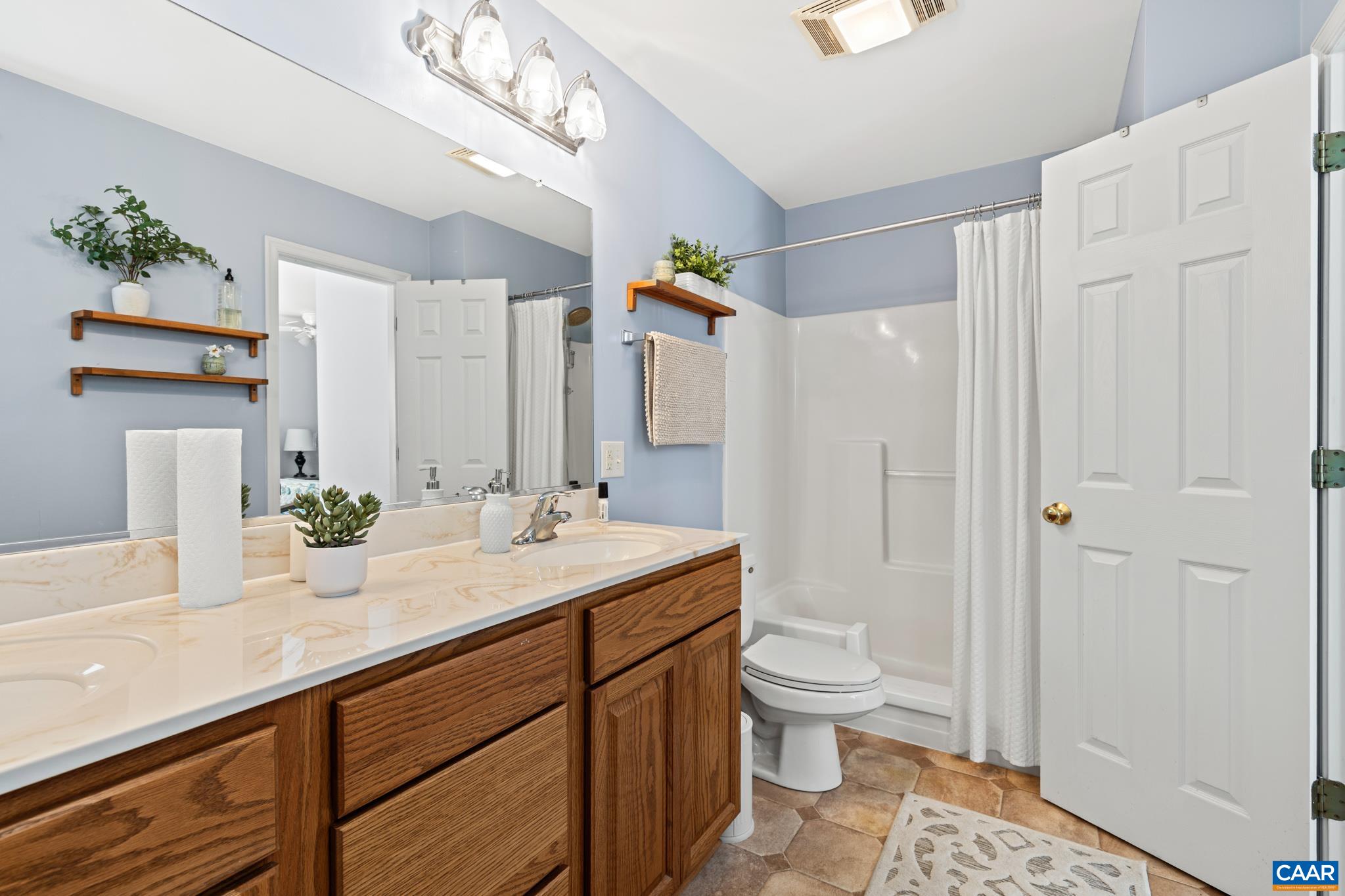 464 Hummingbird Road Scottsville, VA 24590 - Photo 19 of 31 a bathroom with a granite countertop sink a toilet and shower