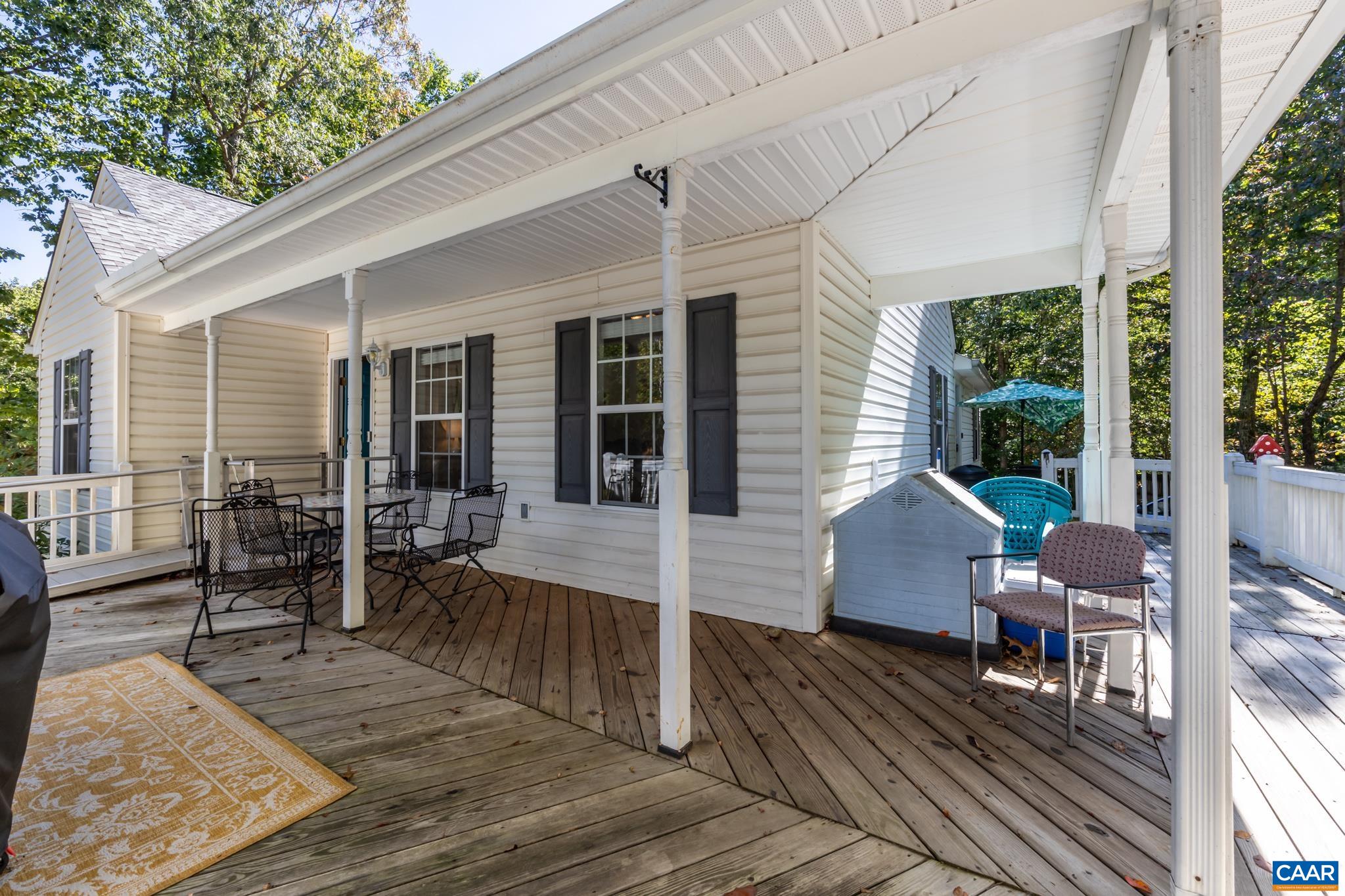 464 Hummingbird Road Scottsville, VA 24590 - Photo 7 of 31 a view of a patio with table and chairs with wooden floor and fence