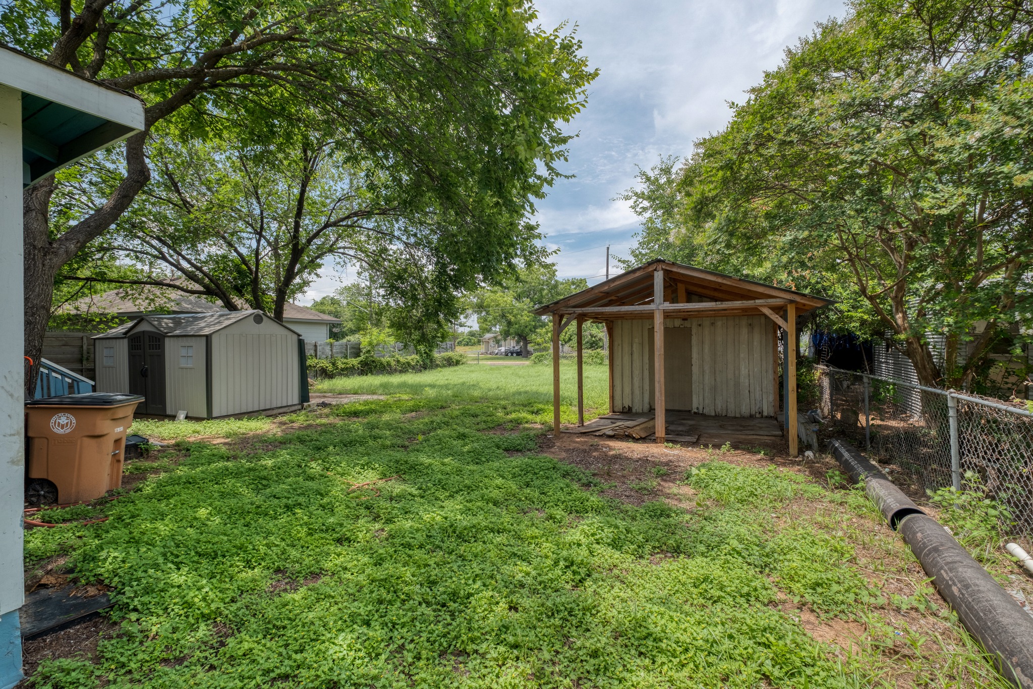 6409 Del Monte Road Austin, TX 78741 - Photo 5 of 15 A generous backyard offers a chain link fence, ample green space, and several storage options.