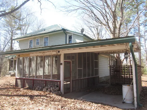 a view of a house with a large window and wooden fence
