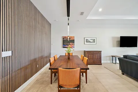 a view of a dining room with furniture large windows and wooden floor