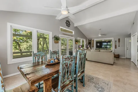 a kitchen with stainless steel appliances granite countertop a stove a sink a dining table and chairs with wooden floor