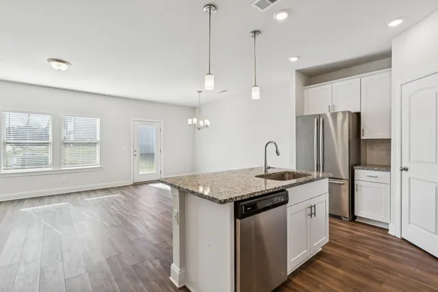 a kitchen with stainless steel appliances granite countertop a sink a refrigerator and a stove