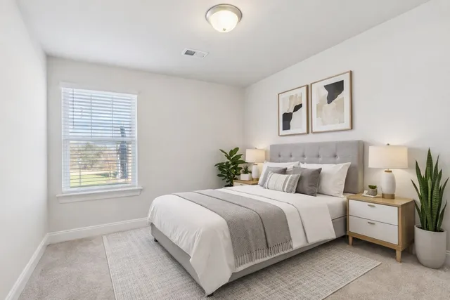 a bedroom with a bed and a potted plant