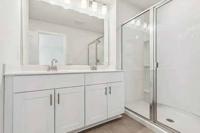 a bathroom with a shower sink and mirror