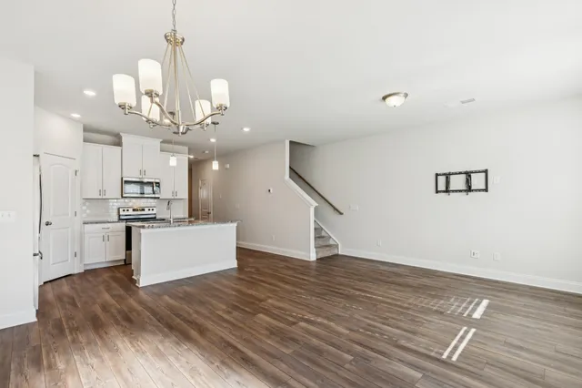 a view of a kitchen with wooden floor and stainless steel appliances