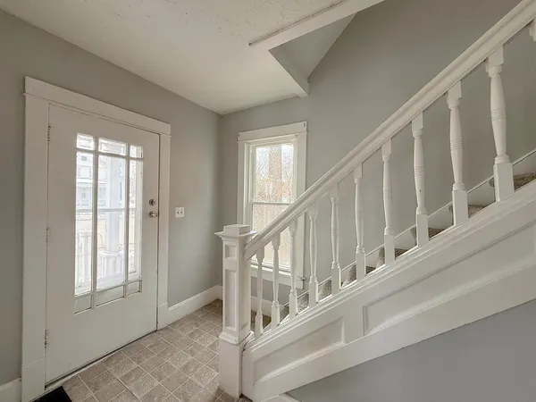 a view of staircase with lots of white walls and a window