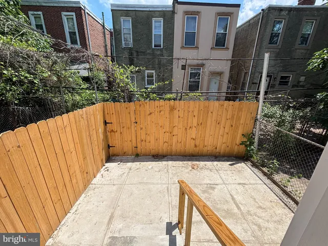 a view of a street with wooden fence
