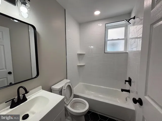 a bathroom with a sink mirror toilet and bathtub