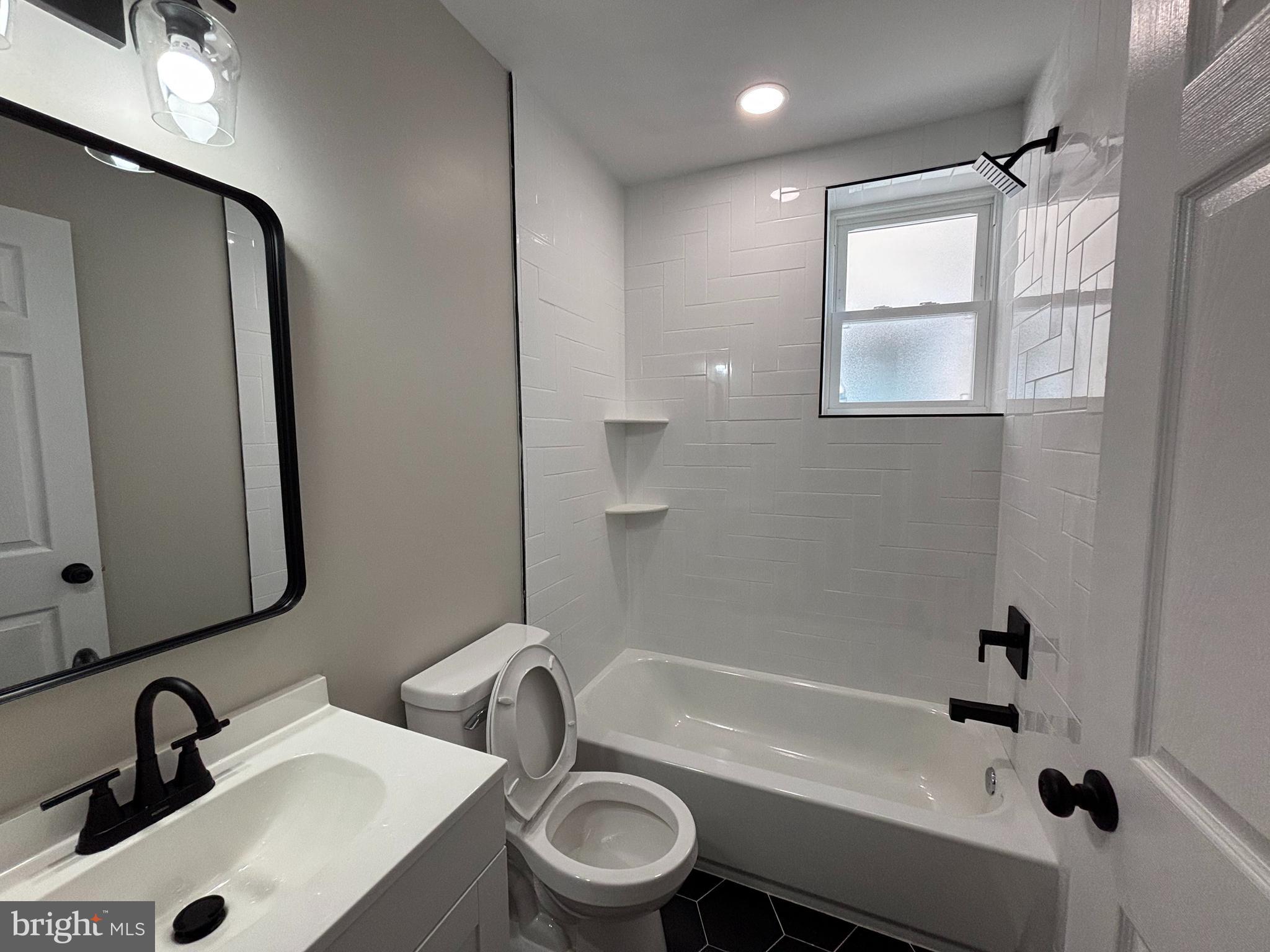 6344 Reedland Street, Unit 2 Philadelphia, PA 19142 - Photo 4 of 6 a bathroom with a sink mirror toilet and bathtub