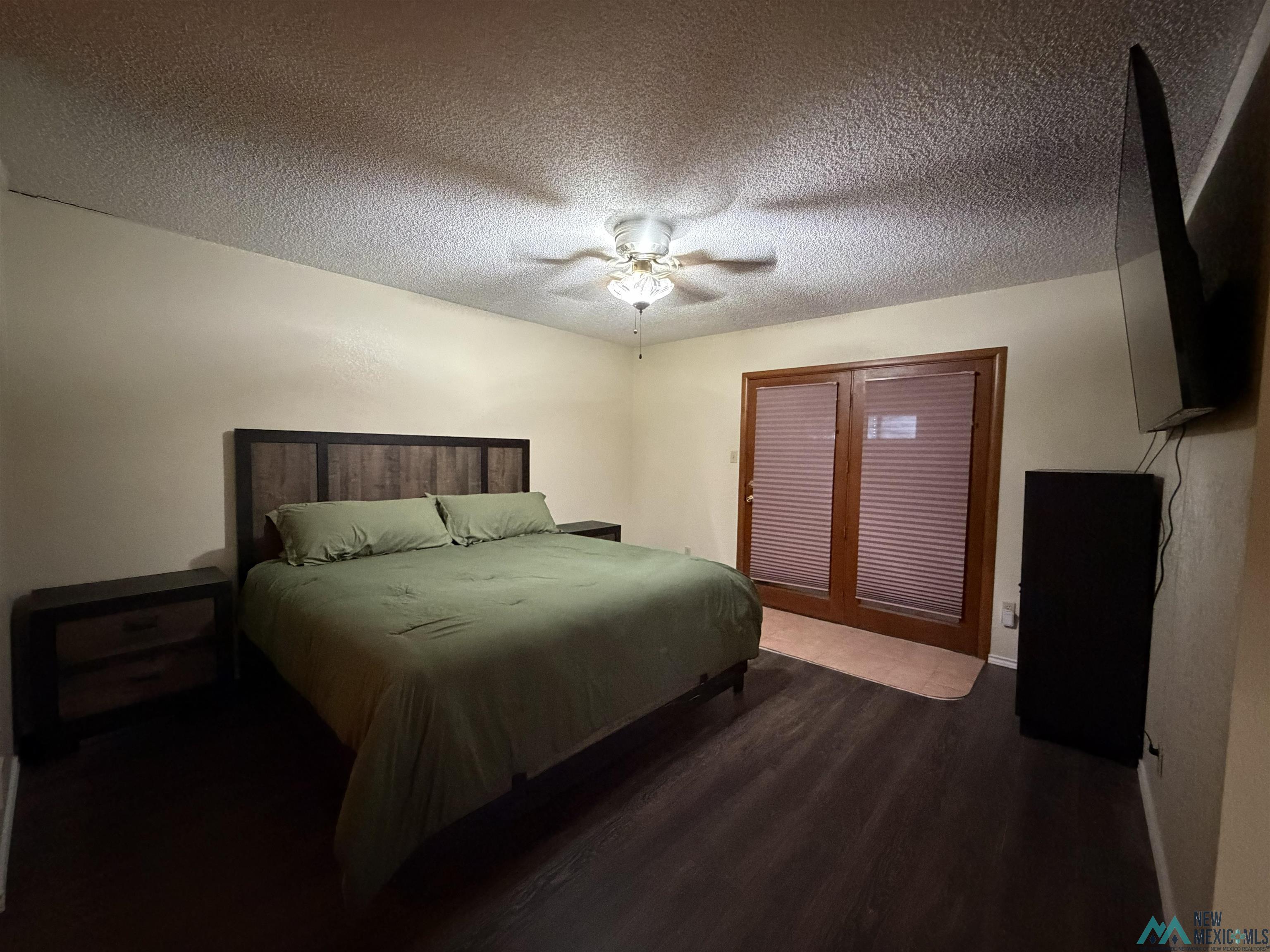 2001 East Derrick Road Carlsbad, NM 88220 - Photo 70 of 84 Bedroom featuring dark wood-type flooring, a textured ceiling, and ceiling fan