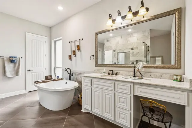a spacious bathroom with a double vanity sink a mirror and a bathtub