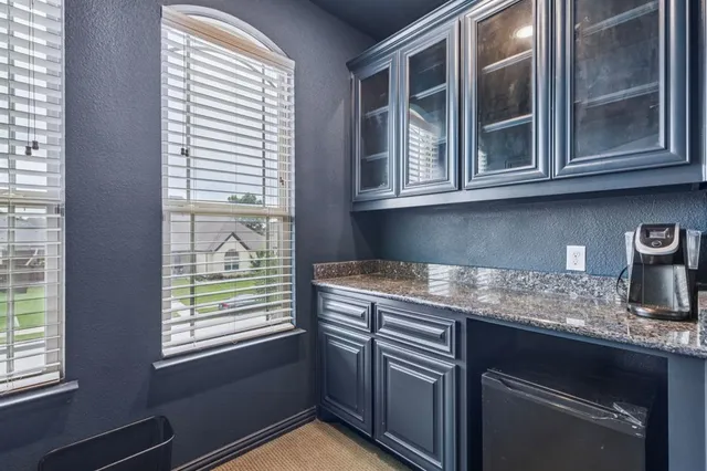 a kitchen with stainless steel appliances granite countertop a sink window and cabinets