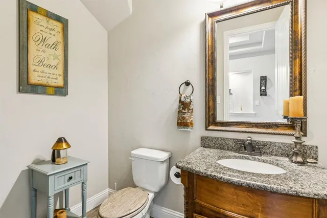 a bathroom with a granite countertop toilet sink and mirror