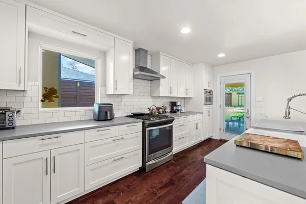 a kitchen with a white wooden cabinets and white appliances