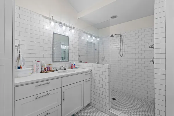 a bathroom with a double vanity sink mirror and shower