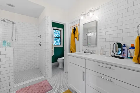 a bathroom with a sink a toilet and shower