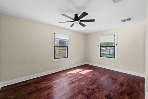 a view of a big room with wooden floor and windows